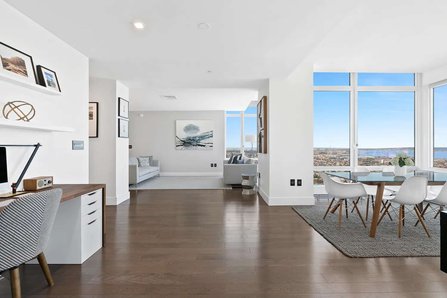a living room with furniture a large window and wooden floor