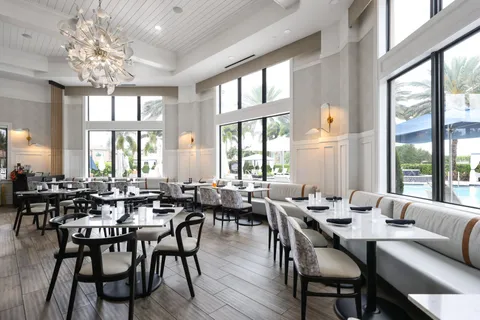 a dining room with furniture a chandelier and wooden floor