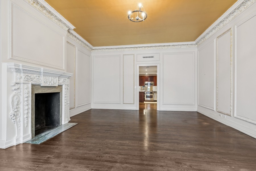 49 East 74th Street Manhattan, NY 10021 - Photo 9 of 11 a view of an empty room with wooden floor and a fireplace