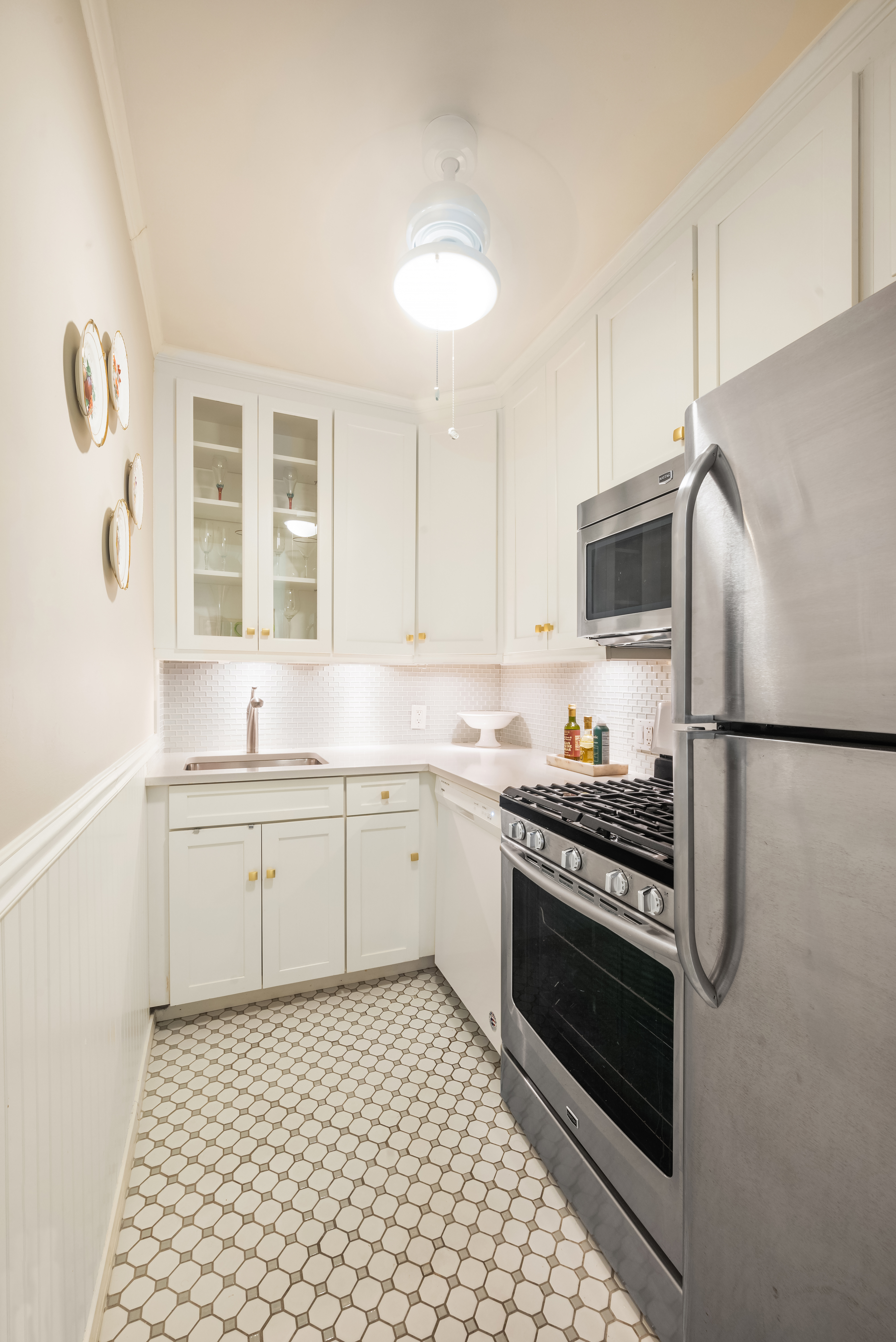 311 East 71st Street, Unit 2B Manhattan, NY 10021 - Photo 5 of 10 a kitchen with a stove a sink and a refrigerator
