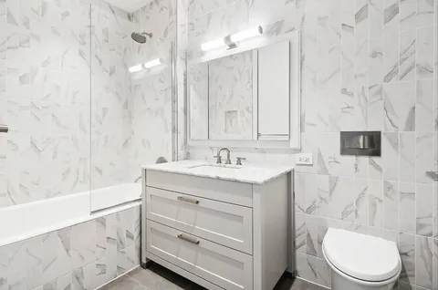 a bathroom with a sink a toilet a mirror and vanity