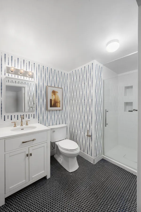 a bathroom with a sink a toilet and a mirror