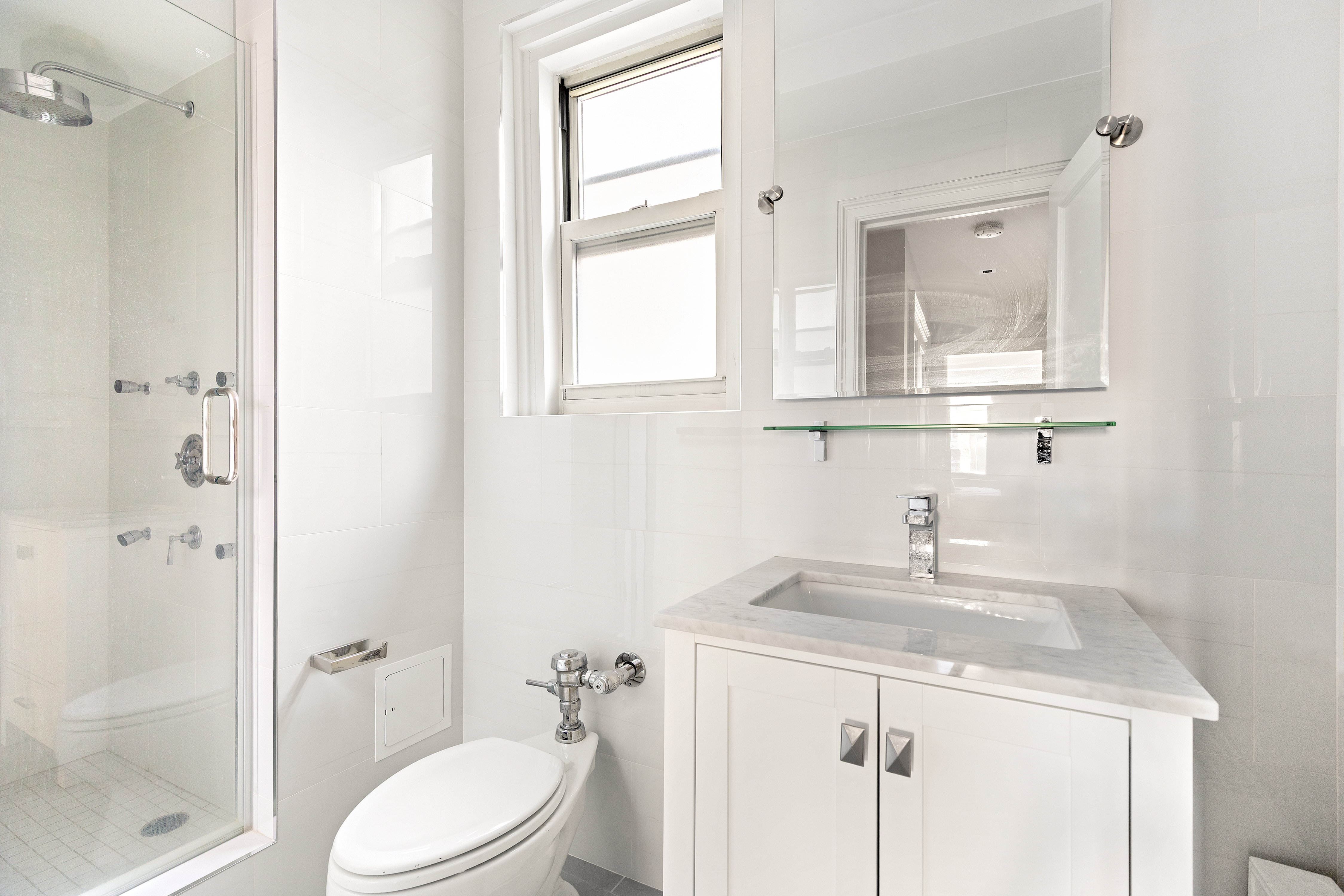 434 East 52nd Street, Unit 10E Manhattan, NY 10022 - Photo 9 of 13 a bathroom with a sink a toilet and shower