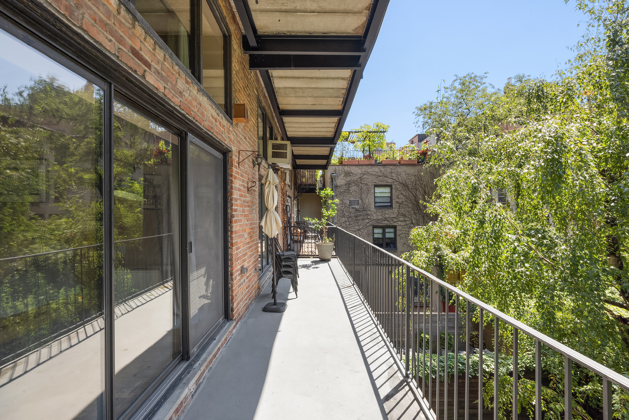 430 West 23rd Street, Unit C Manhattan, NY 10011 - Photo 5 of 16 a view of a balcony with wooden floor and stairs