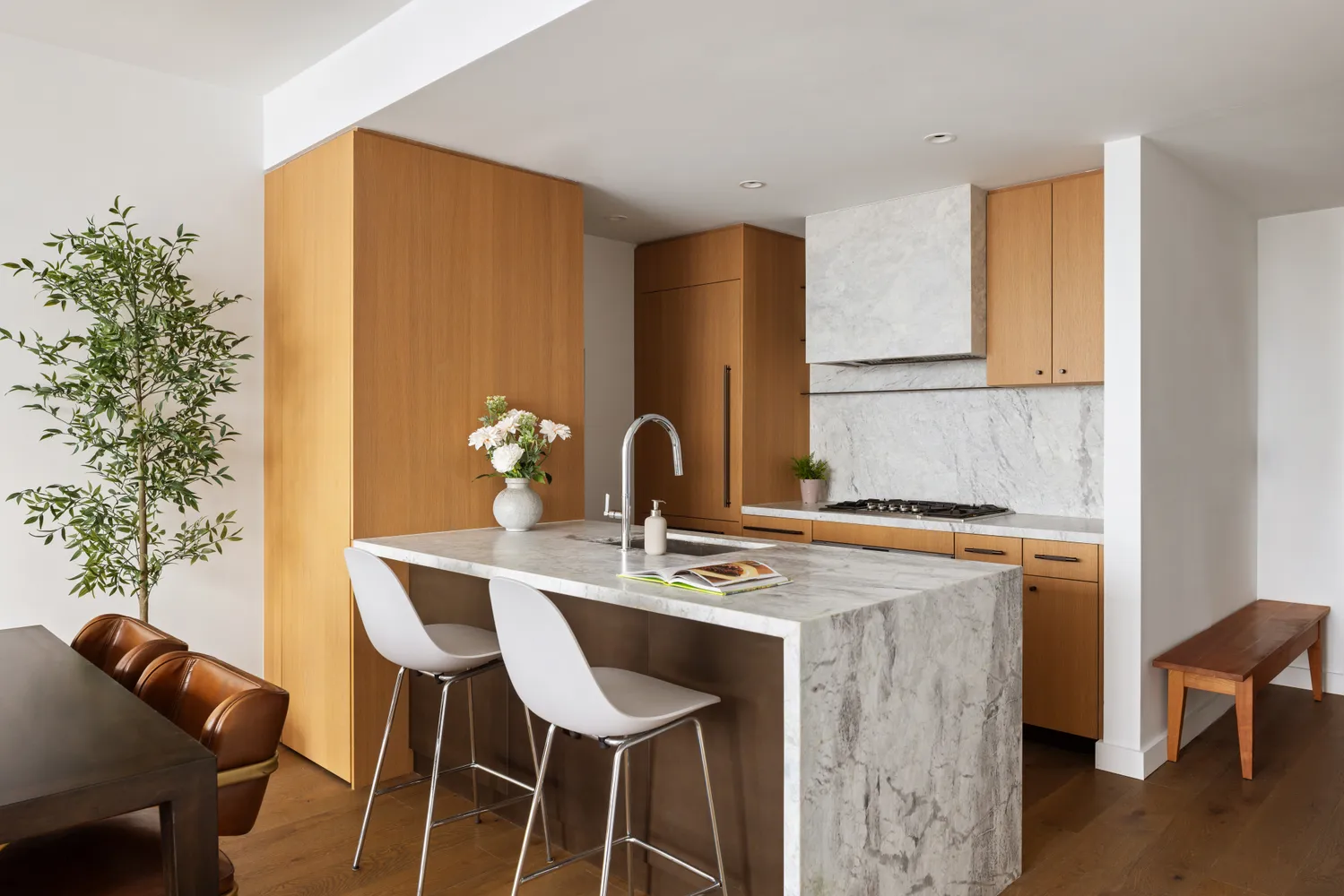 a dining table with chairs and a potted plant