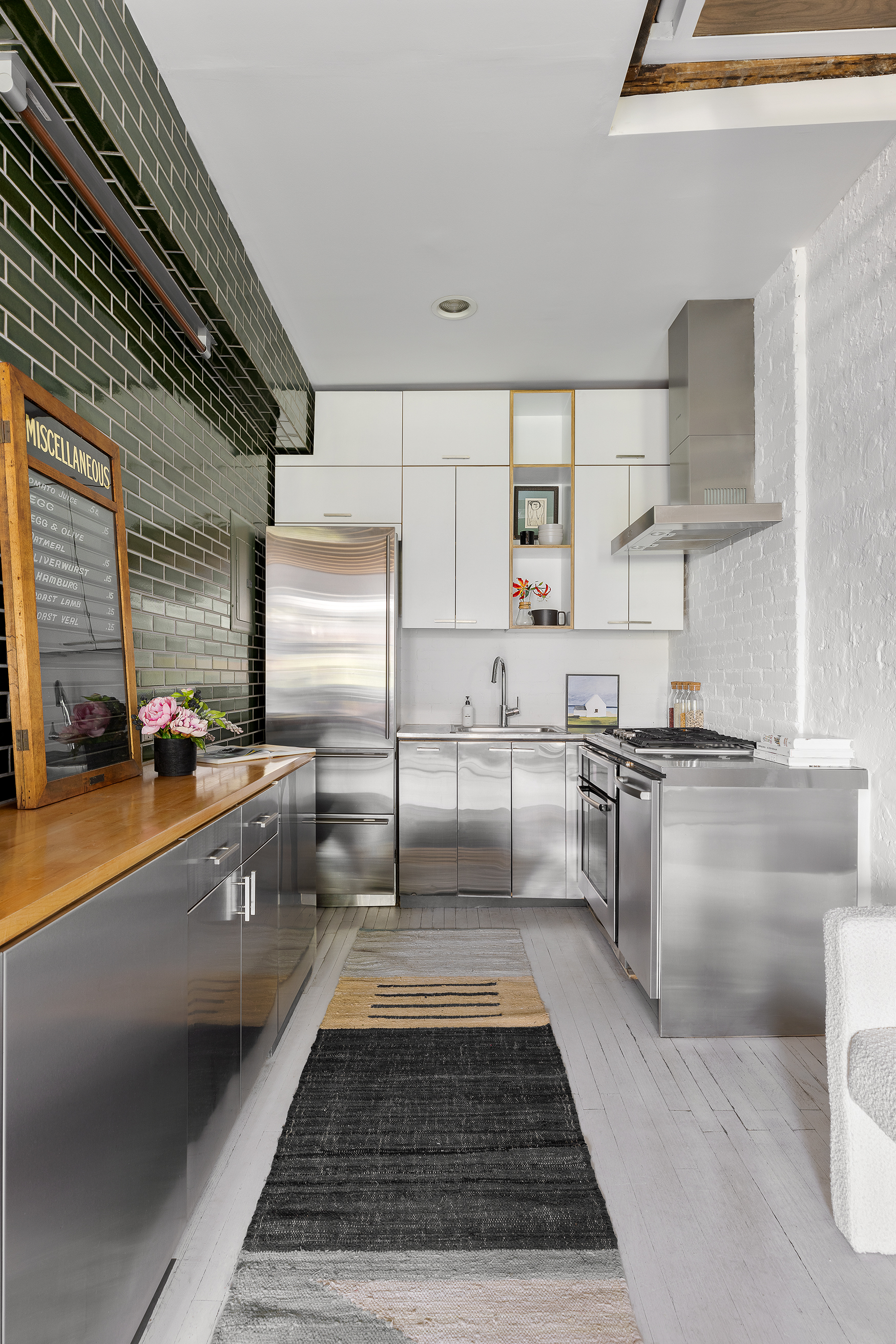 281 West 11th Street, Unit 4/5C Manhattan, NY 10014 - Photo 10 of 18 a kitchen with counter top space cabinets stainless steel appliances and a counter top space