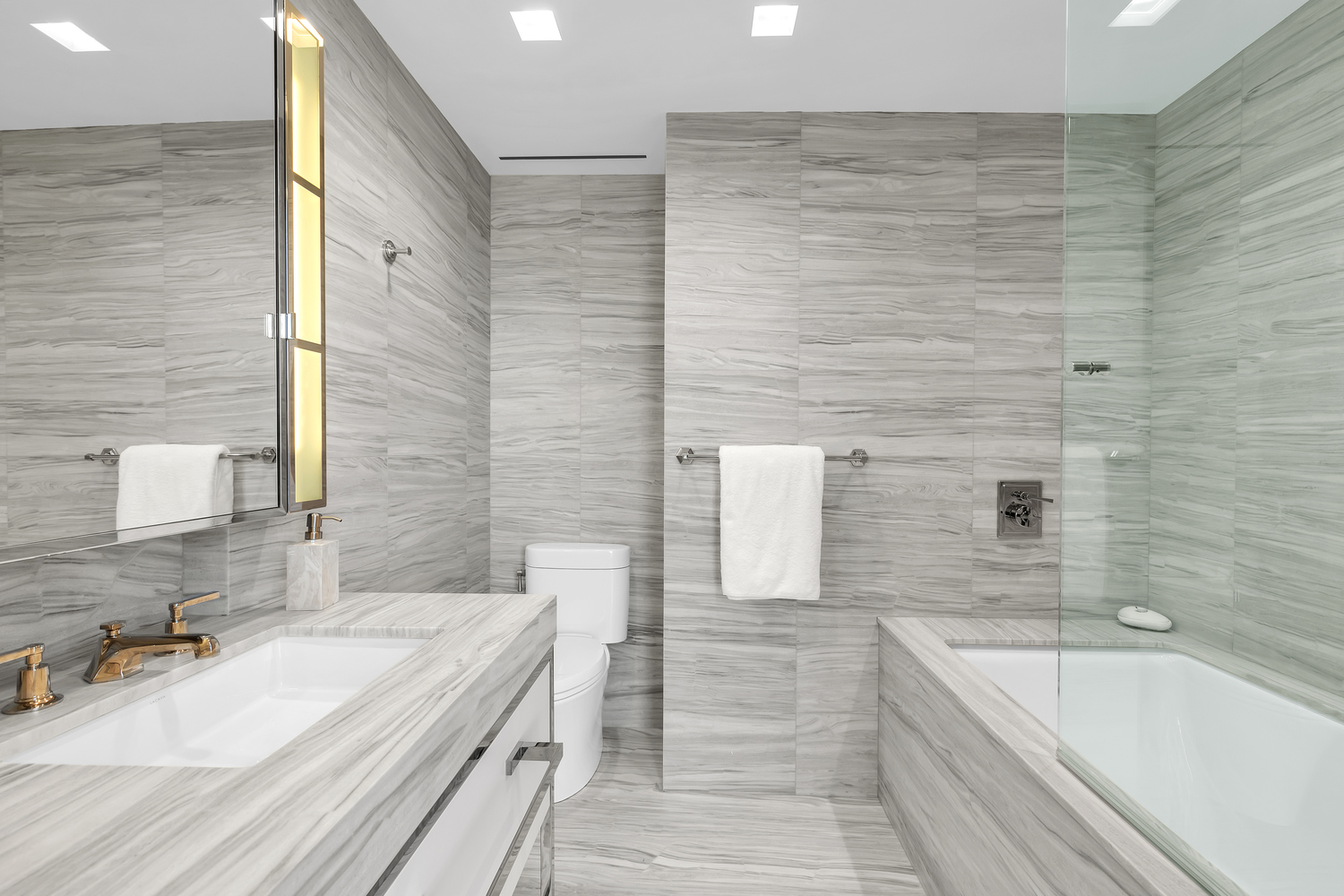 23 East 22nd Street, Unit PH Manhattan, NY 10010 - Photo 15 of 32 a bathroom with a granite countertop bathtub sink vanity and mirror