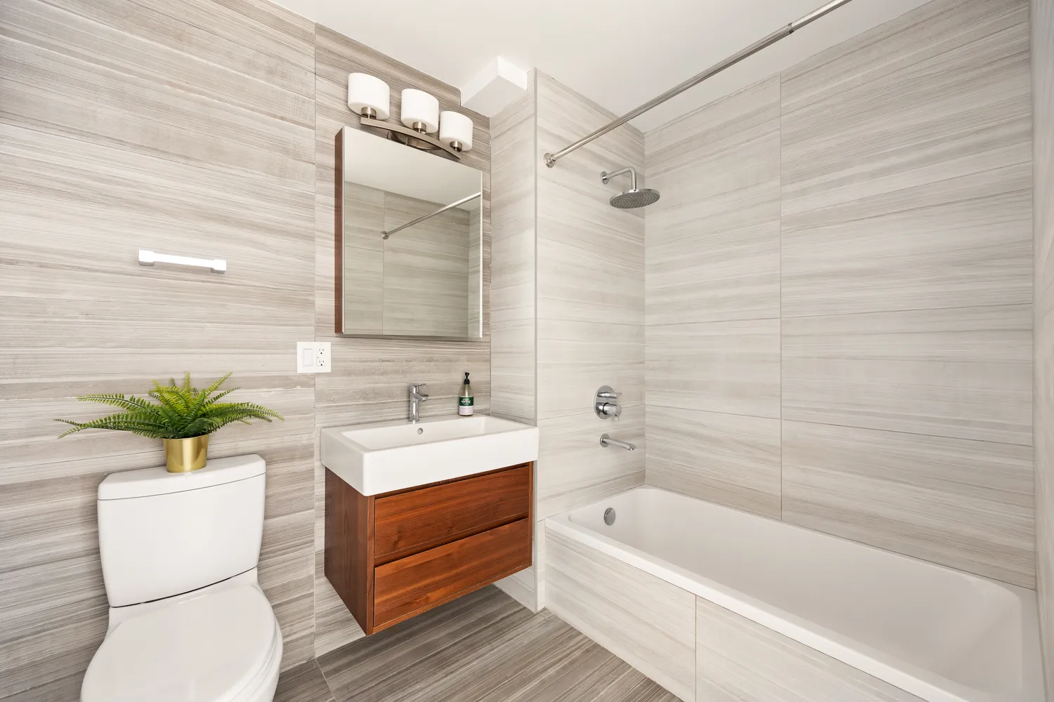 a bathroom with a sink a toilet a mirror and shower