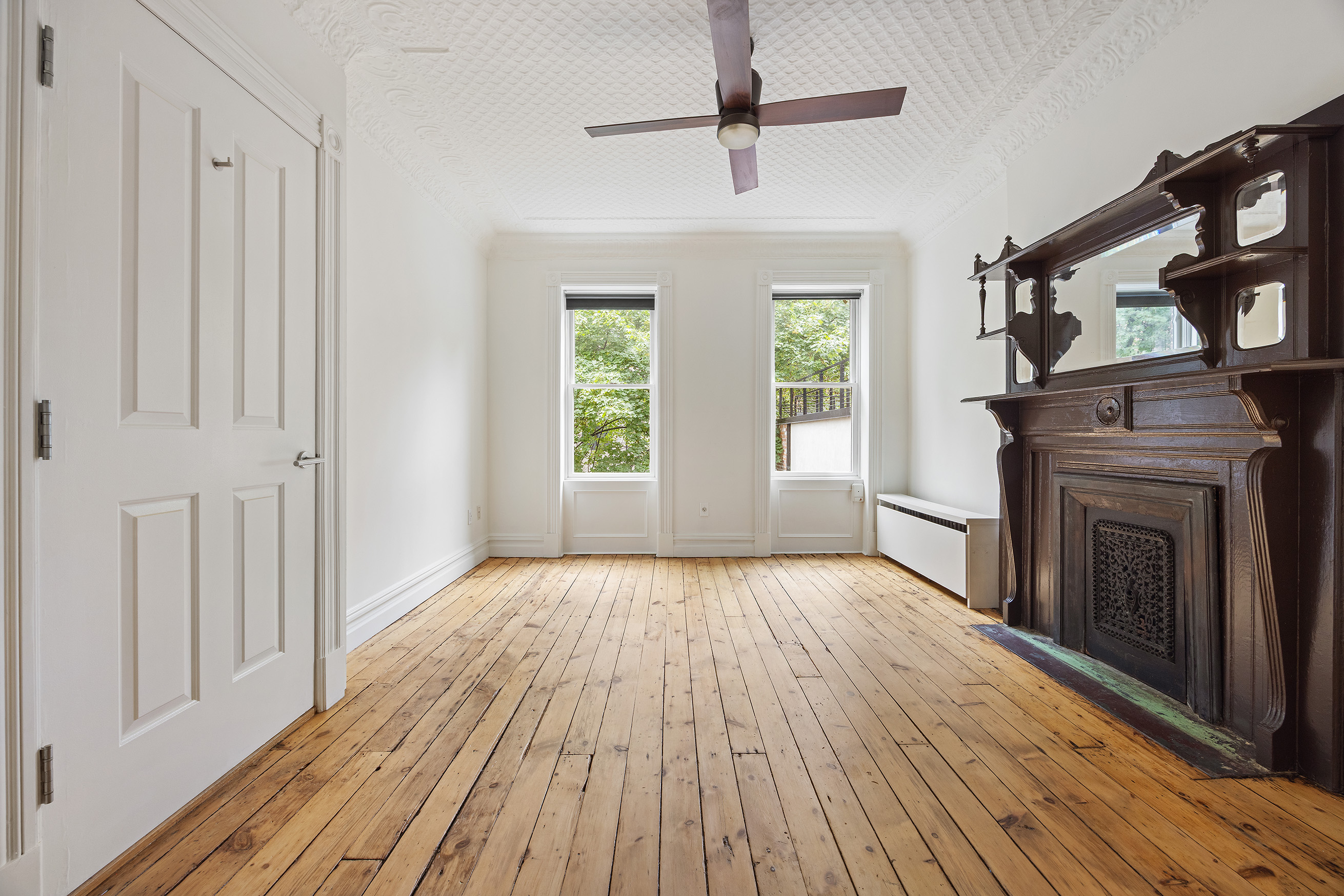 64 Clifton Place, Unit 2 Brooklyn, NY 11238 - Photo 8 of 16 a view of an empty room with wooden floor fireplace and a window