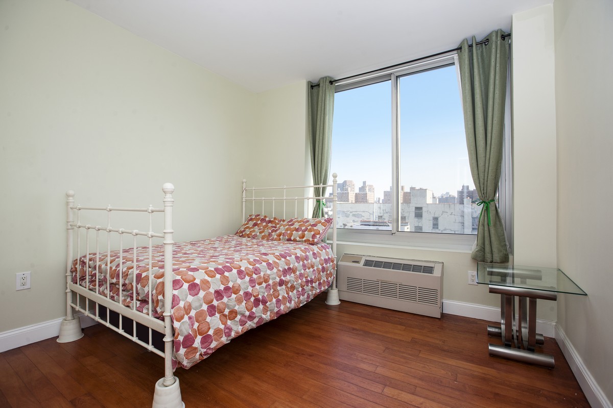 249 East 118th Street, Unit 7A Manhattan, NY 10035 - Photo 4 of 9 a bedroom with a bed and a large window