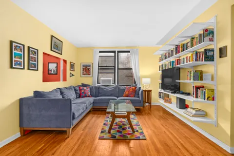 a living room with furniture and a book shelf