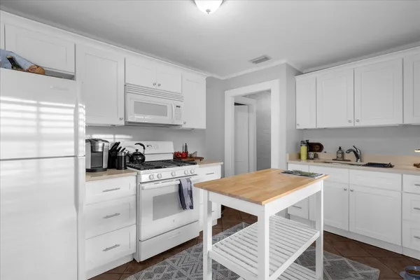 a kitchen with white cabinets and white appliances