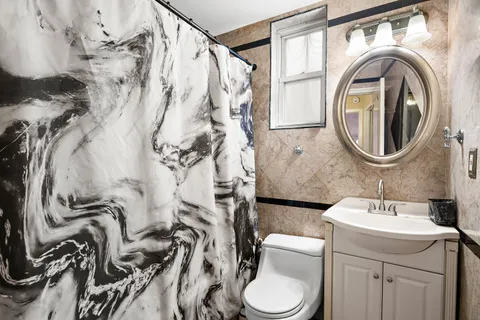 a bathroom with a toilet sink and mirror