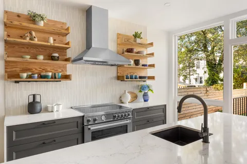 a kitchen with stainless steel appliances granite countertop a sink a stove and a wooden floor