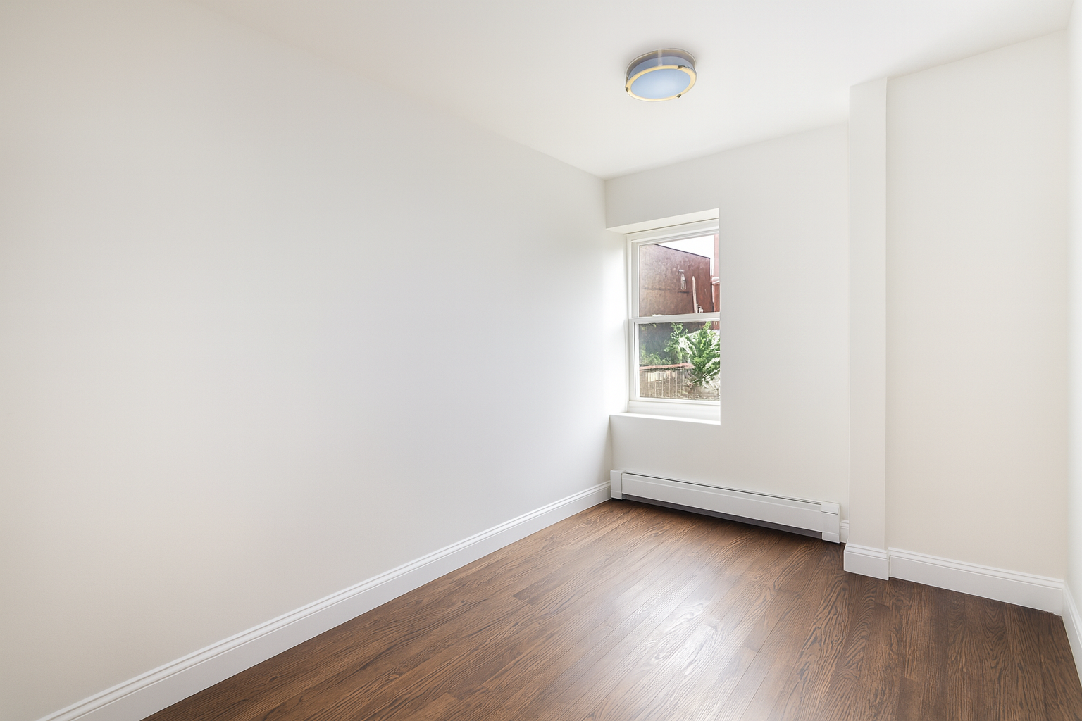 187 Woodpoint Road Brooklyn, NY 11211 - Photo 9 of 17 an empty room with wooden floor and windows