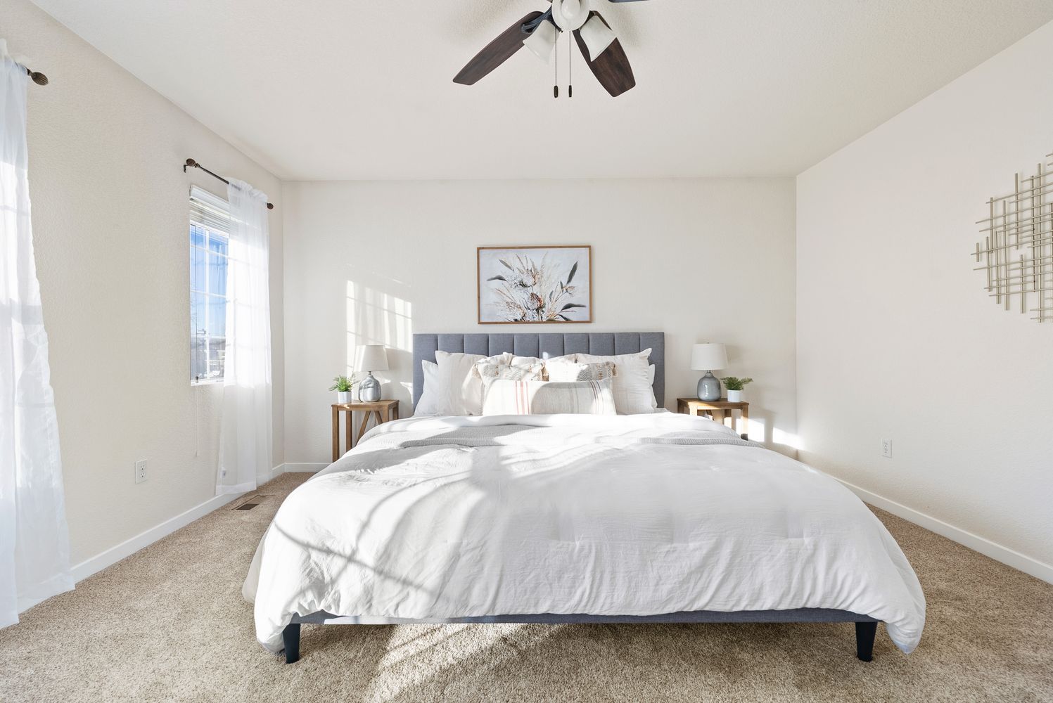a bedroom with a bed and painting on the wall