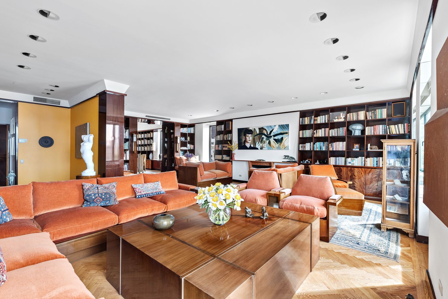 a living room with furniture kitchen view and a large window