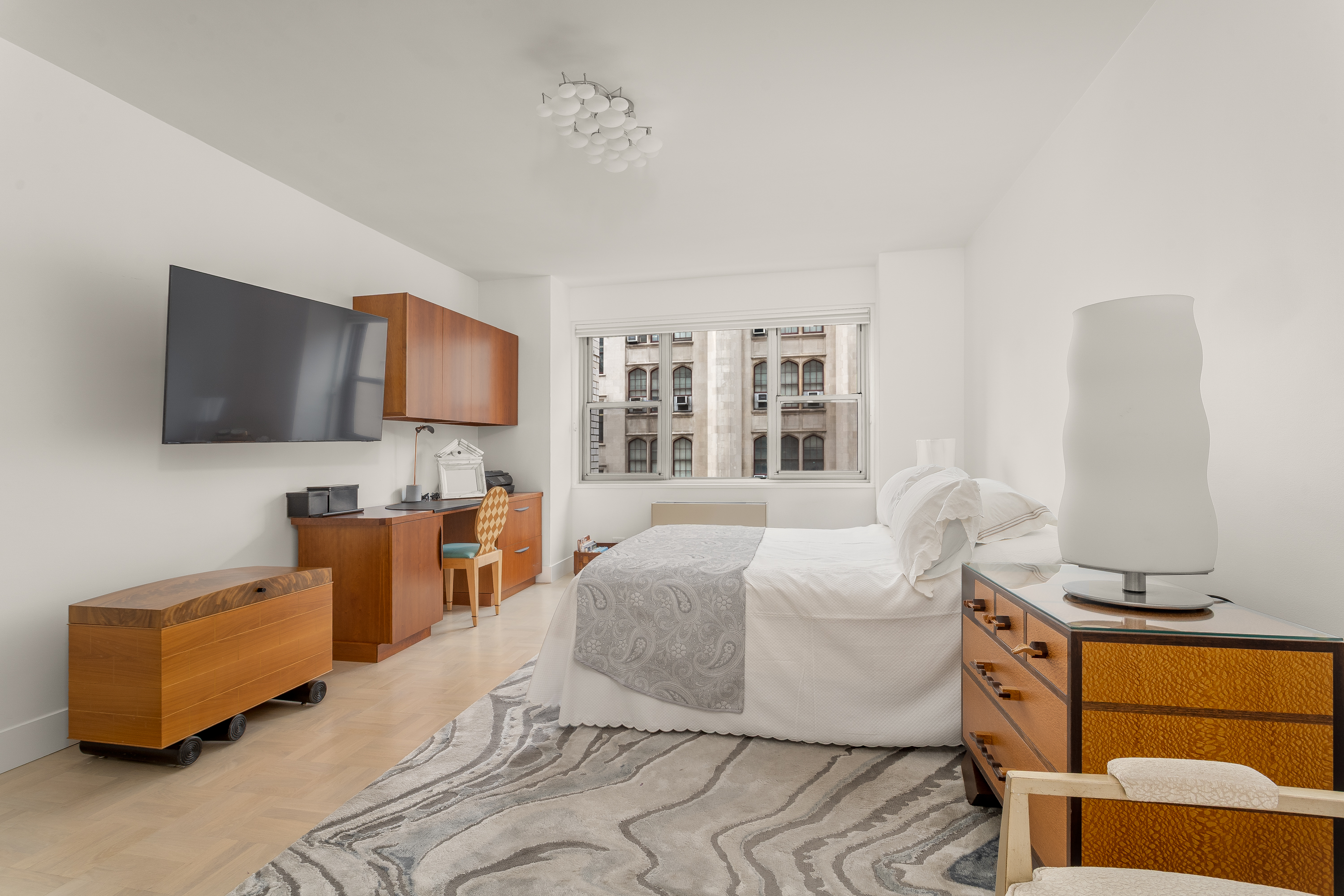 150 East 69th Street, Unit 5C Manhattan, NY 10021 - Photo 8 of 15 a bedroom with furniture and a flat screen tv