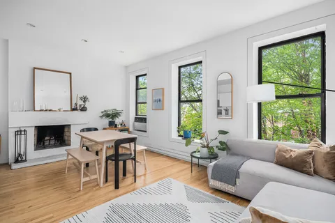 a living room with furniture a fireplace and a large window