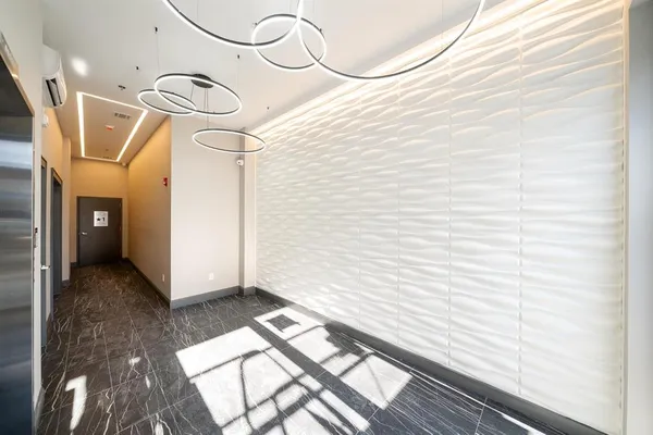 a view of a hallway with wooden floor and a bathroom