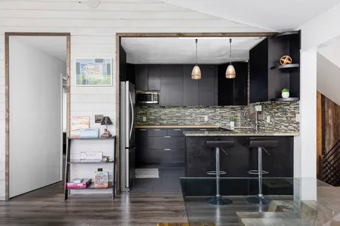a kitchen with kitchen island granite countertop a sink and cabinets