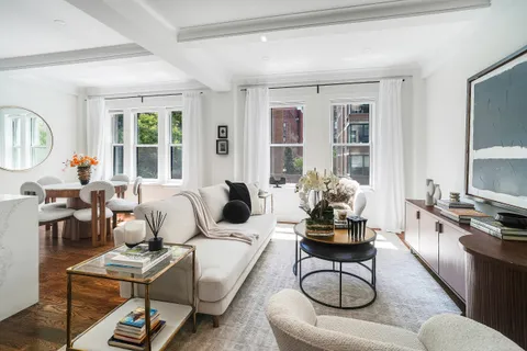 a living room with furniture a rug and a floor to ceiling window