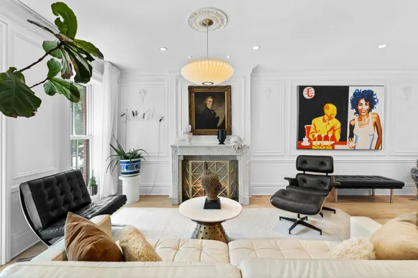 a living room with furniture a fireplace and wall paintings
