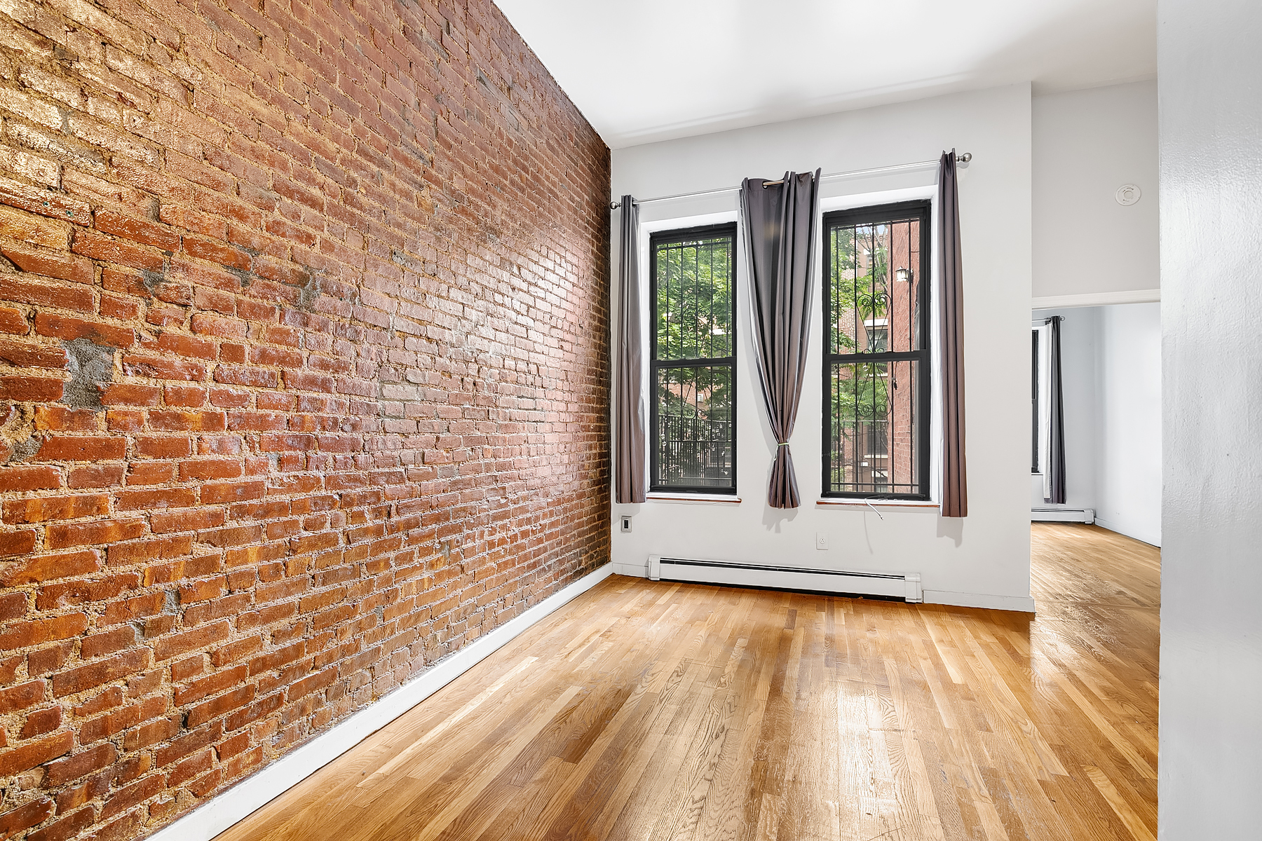 357 West 120th Street, Unit 1R Manhattan, NY 10027 - Photo 1 of 9 a view of an empty room with wooden floor and a window
