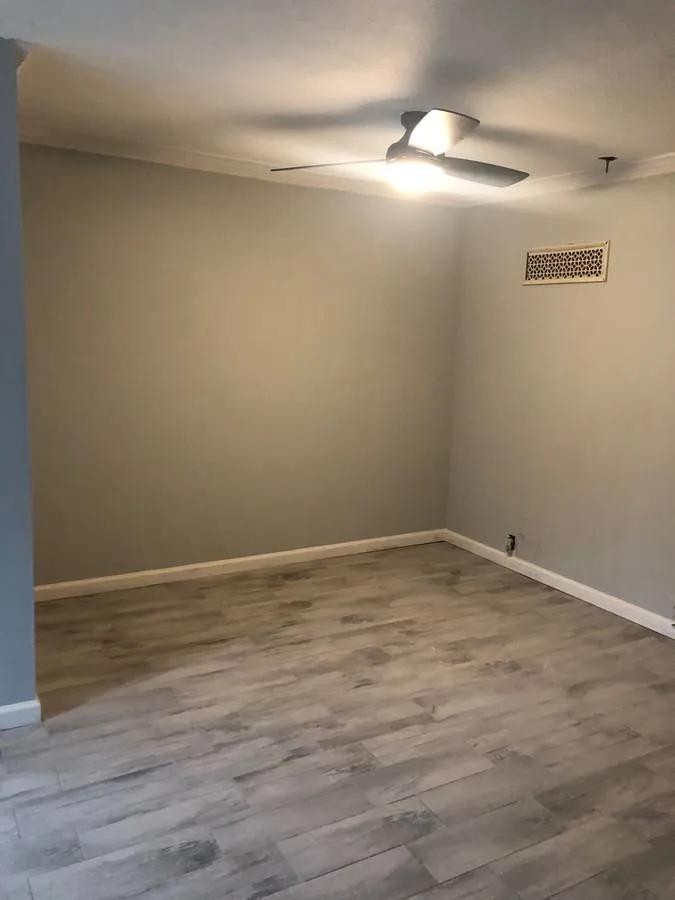 a view of an empty room with wooden floor