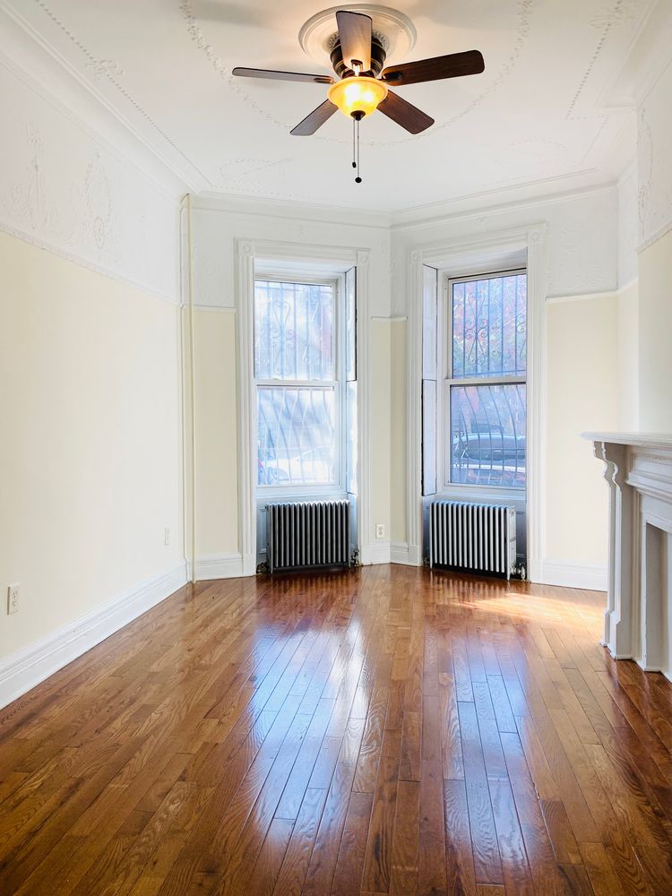 23 Saint Marks Avenue, Unit 3 Brooklyn, NY 11217 - Photo 5 of 10 an empty room with wooden floor chandelier fan and windows