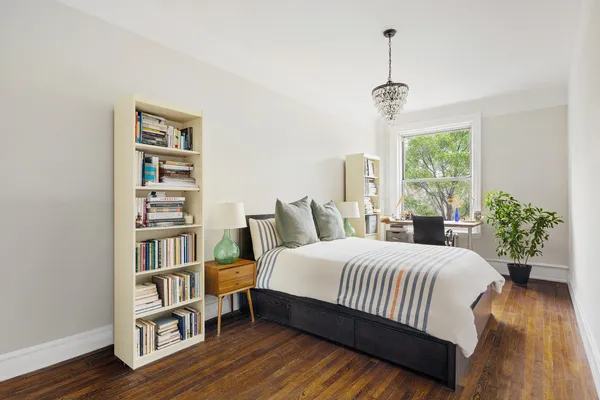 a bedroom with a bed furniture and a book shelf