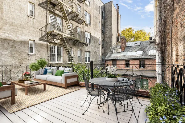 a view of a patio with couches table and chairs and potted plants