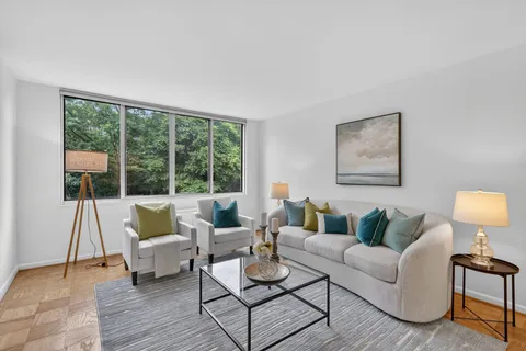 a living room with furniture and a painting on the wall