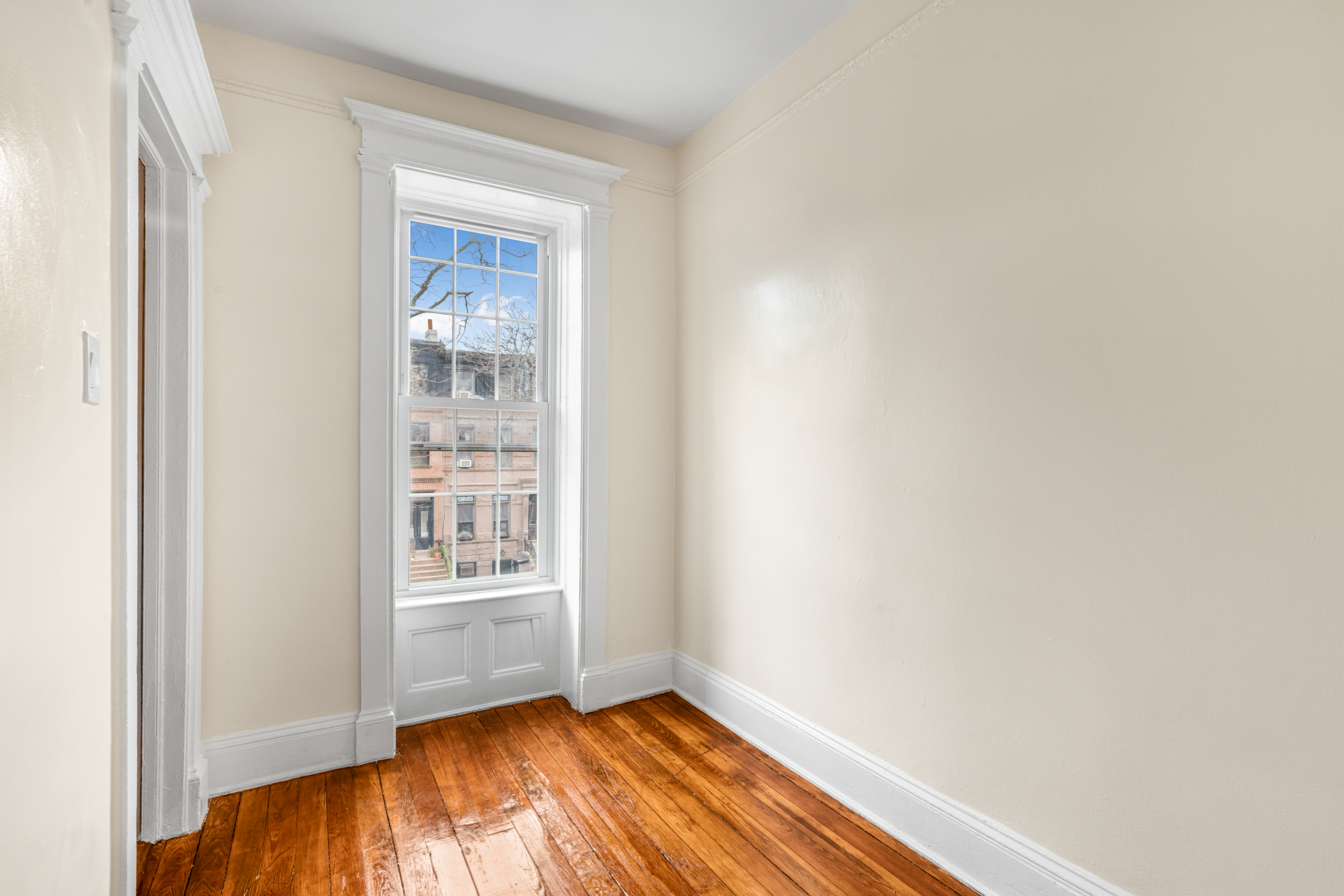 601 Jefferson Avenue, Unit 2 Brooklyn, NY 11221 - Photo 5 of 8 a view of an empty room with wooden floor and a window