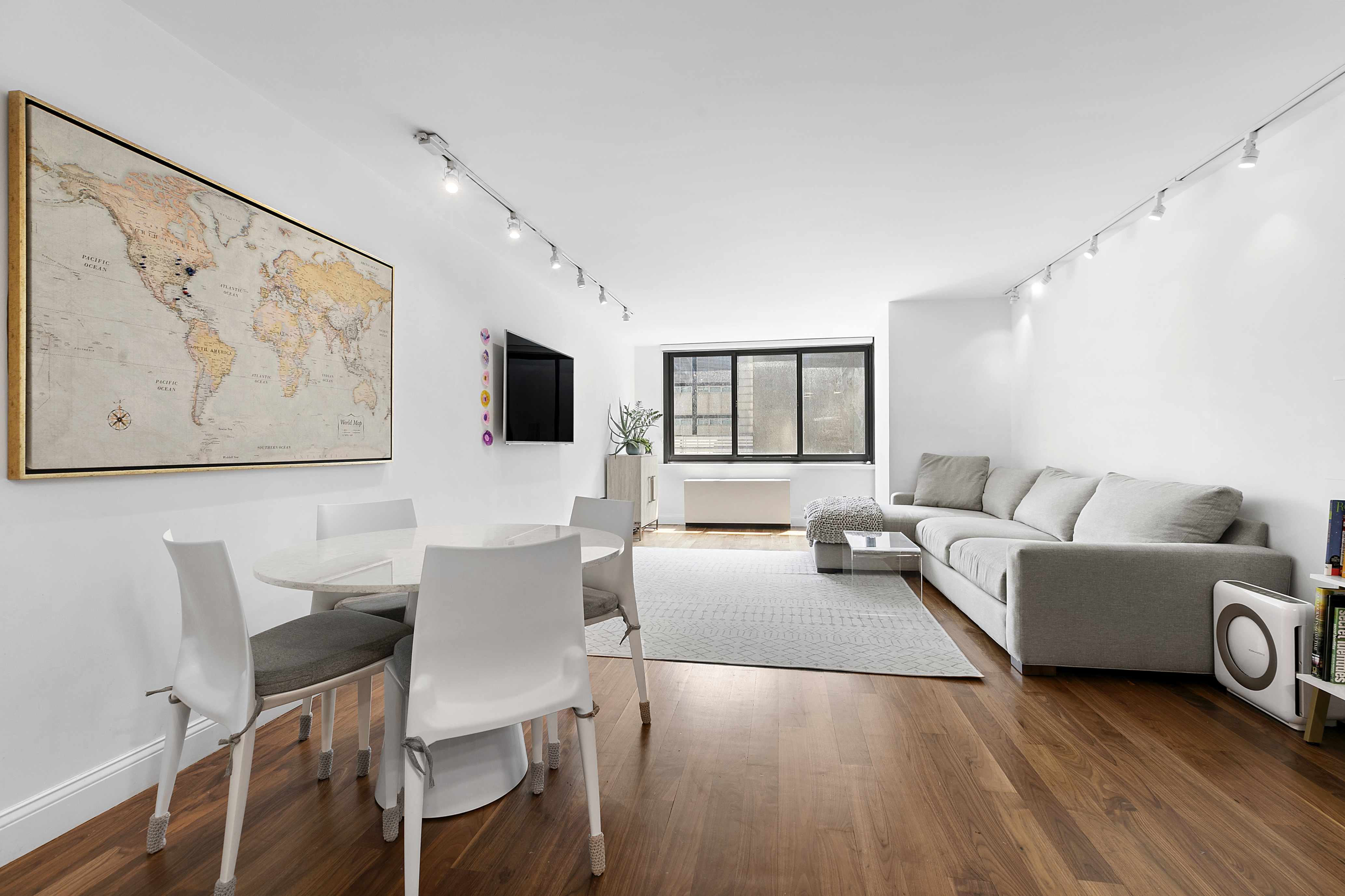 a living room with furniture a flat screen tv and kitchen view