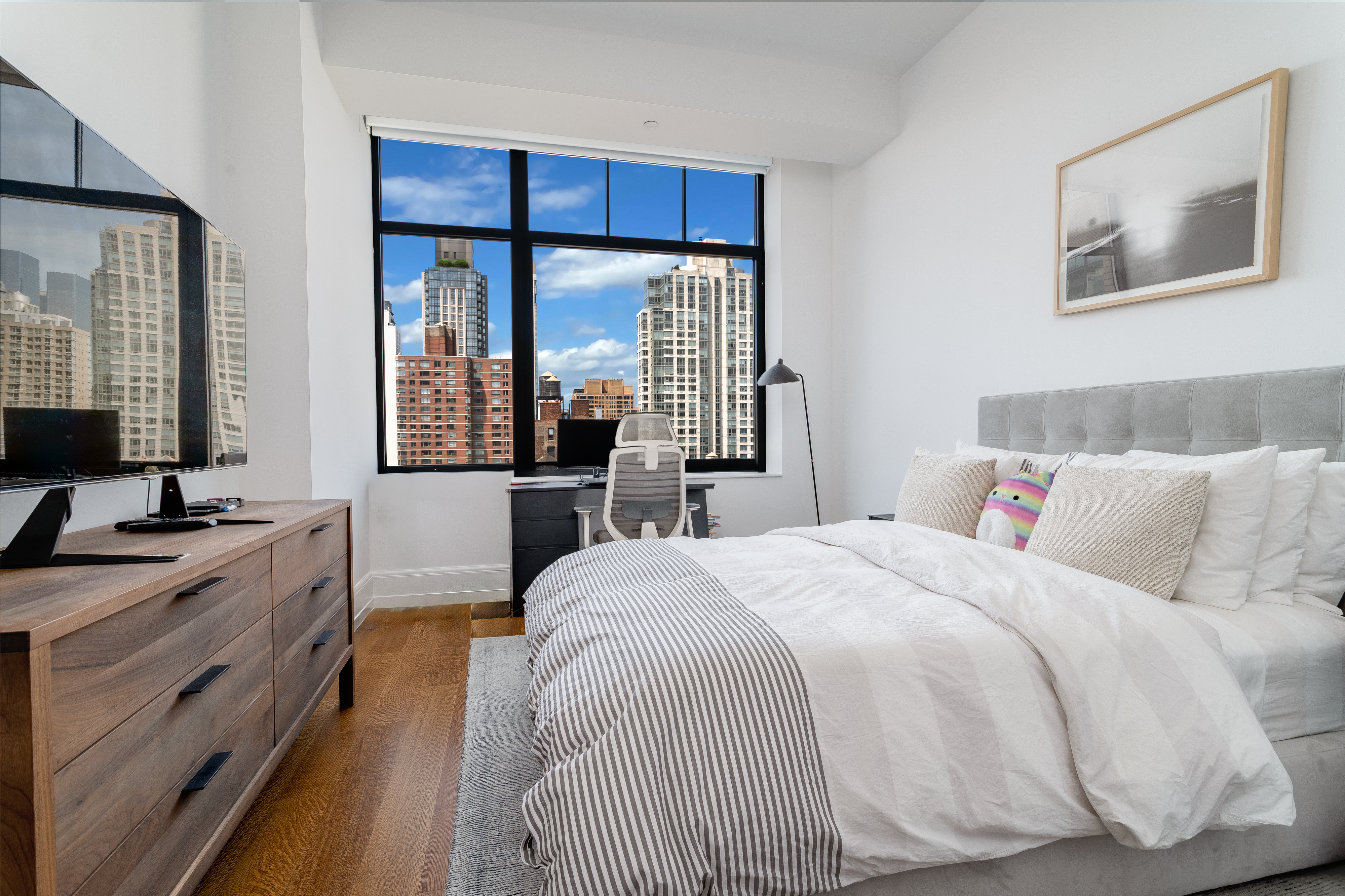 10 Madison Square West, Unit 16F Manhattan, NY 10010 - Photo 12 of 15 a bedroom with a large bed and a flat tv screen on dresser