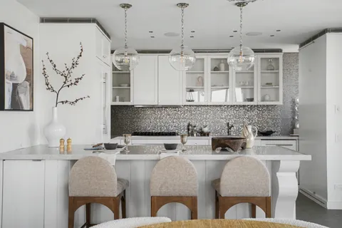 a kitchen with stainless steel appliances granite countertop a table and chairs in it
