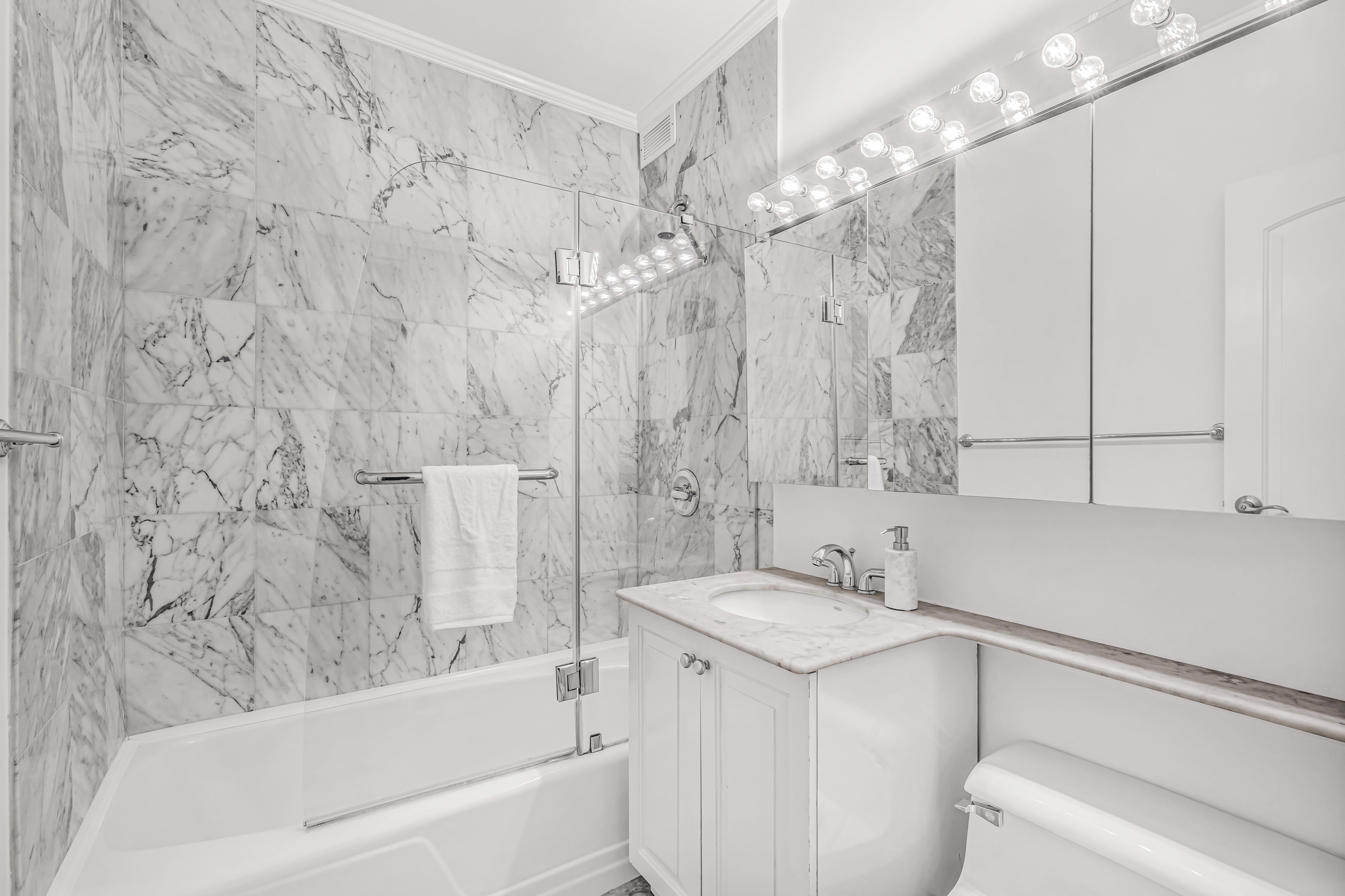 203 East 72nd Street, Unit 3E Manhattan, NY 10021 - Photo 5 of 6 a bathroom with a sink a toilet and bathtub