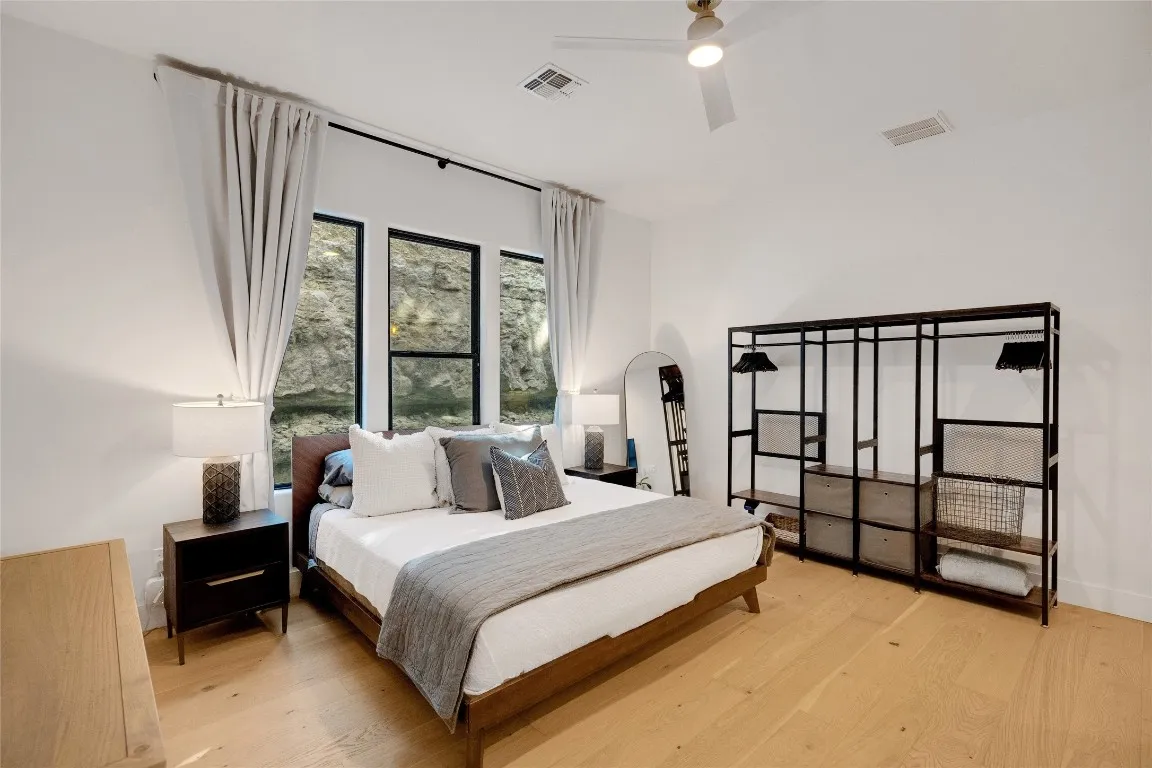 a bedroom with a bed wall painting and a window