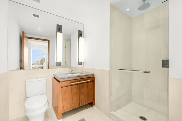 a bathroom with a granite countertop sink a toilet and shower