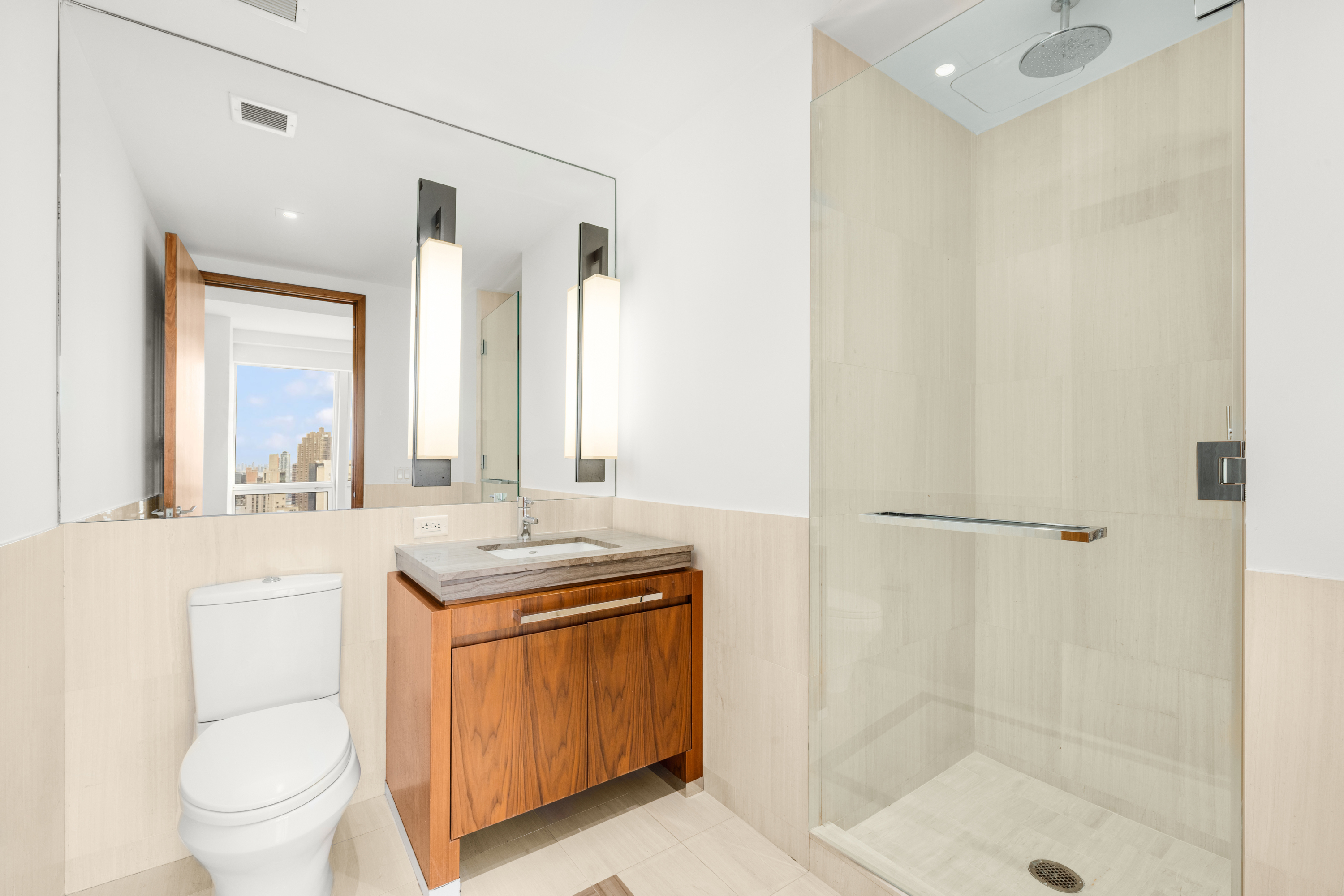 400 5th Avenue, Unit 37C Manhattan, NY 10018 - Photo 8 of 19 a bathroom with a granite countertop sink a toilet and shower