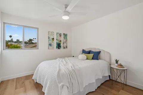 a bedroom with a bed table and chair
