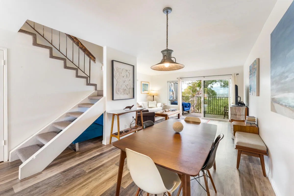 a view of a dining room and livingroom with furniture wooden floor a chandelier
