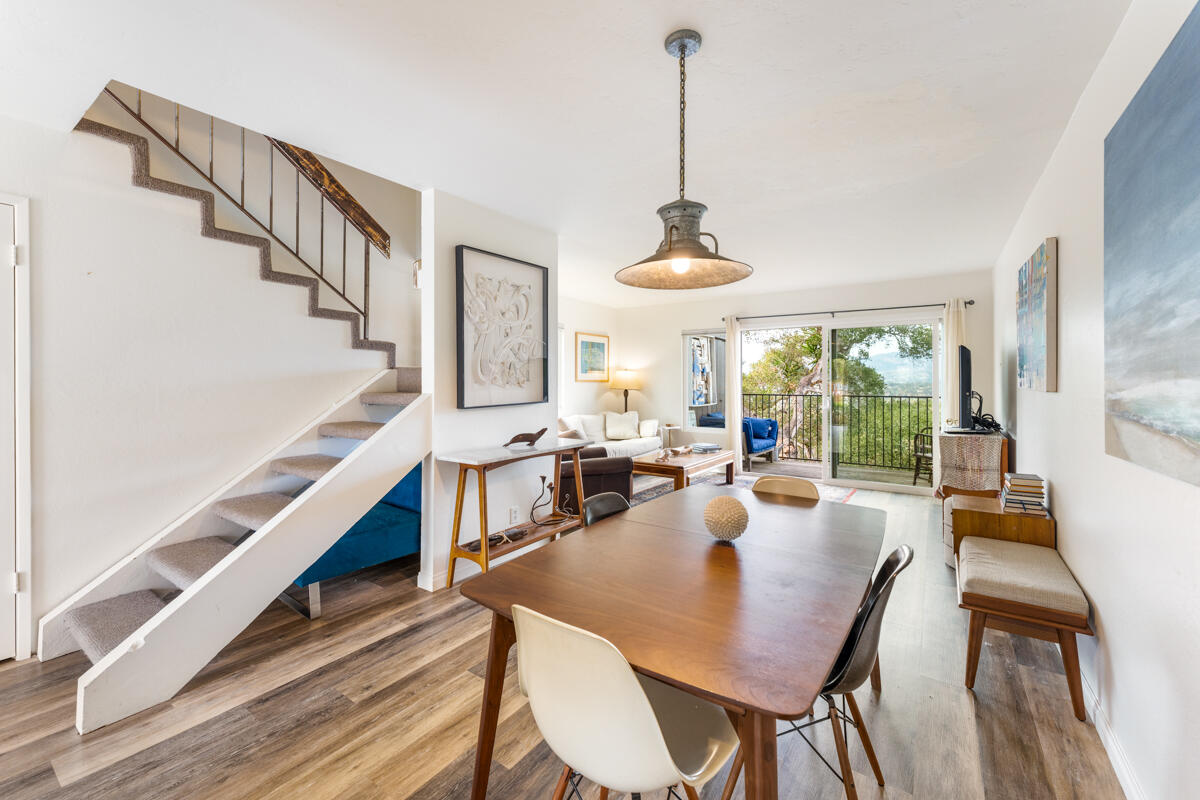 a view of a dining room and livingroom with furniture wooden floor a chandelier
