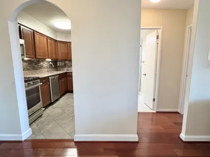 an empty room with wooden floor and cabinets