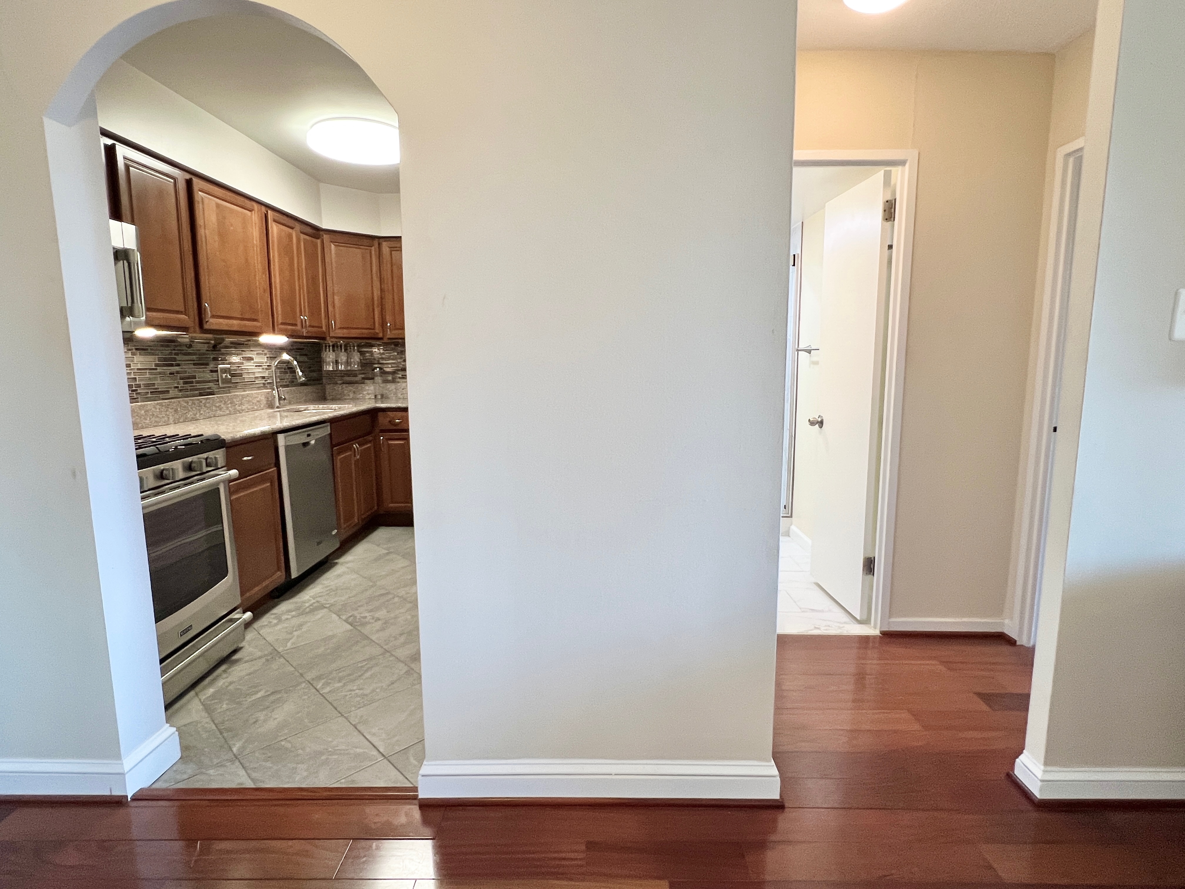 490 M Street Southwest, Unit W304 Washington, DC 20024 - Photo 11 of 36 an empty room with wooden floor and cabinets