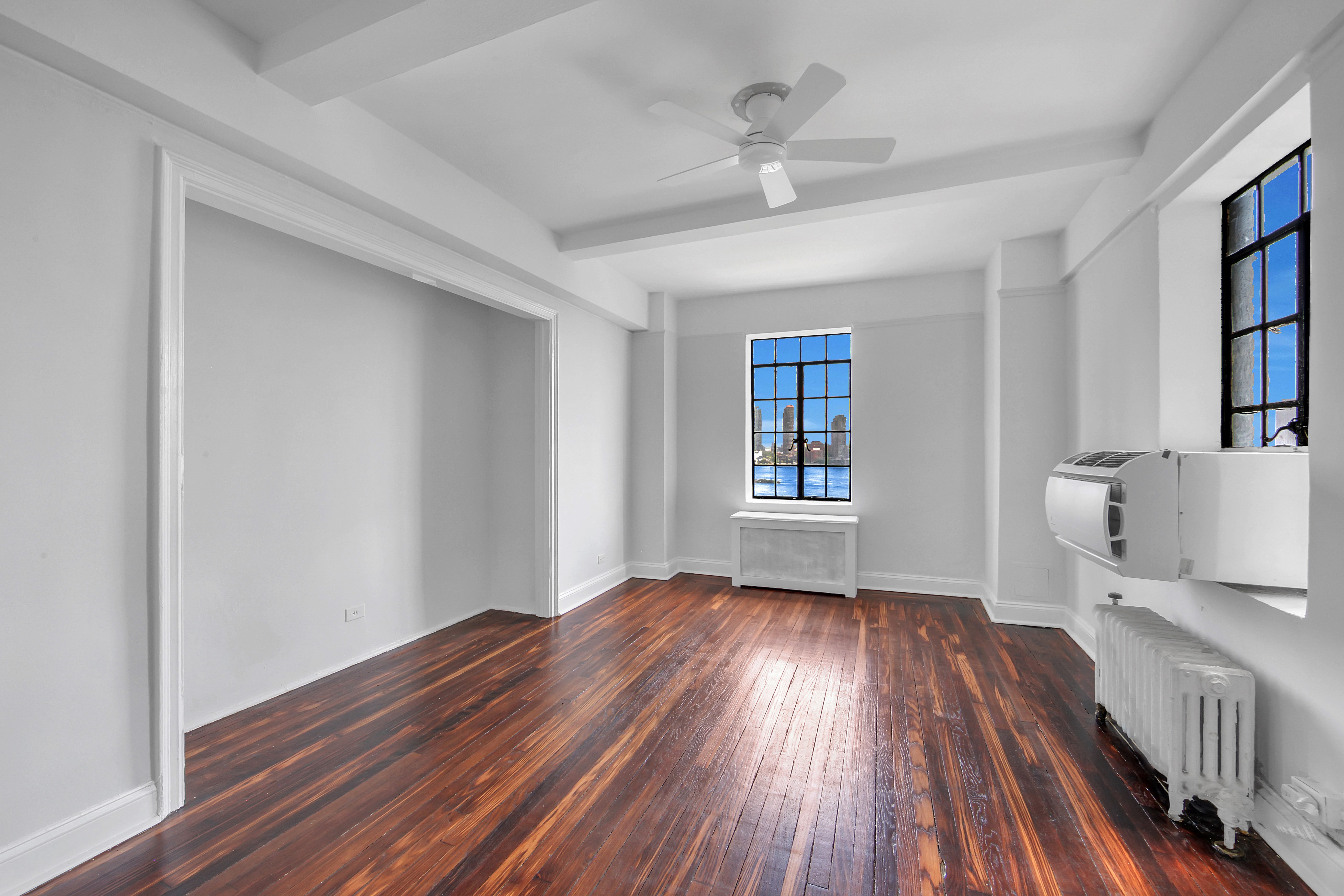 5 Tudor City Place, Unit 536 Manhattan, NY 10017 - Photo 5 of 14 wooden floor in an empty room with a window