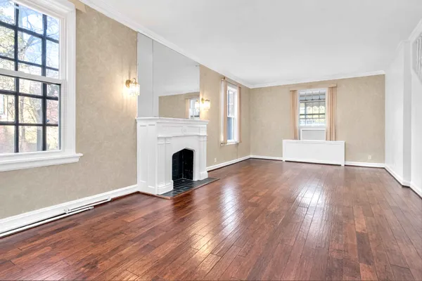 a view of empty room with wooden floor and fireplace