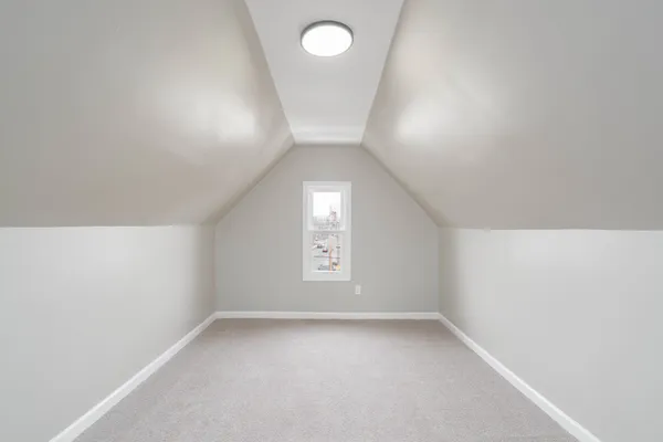 an empty room with a window and a mirror