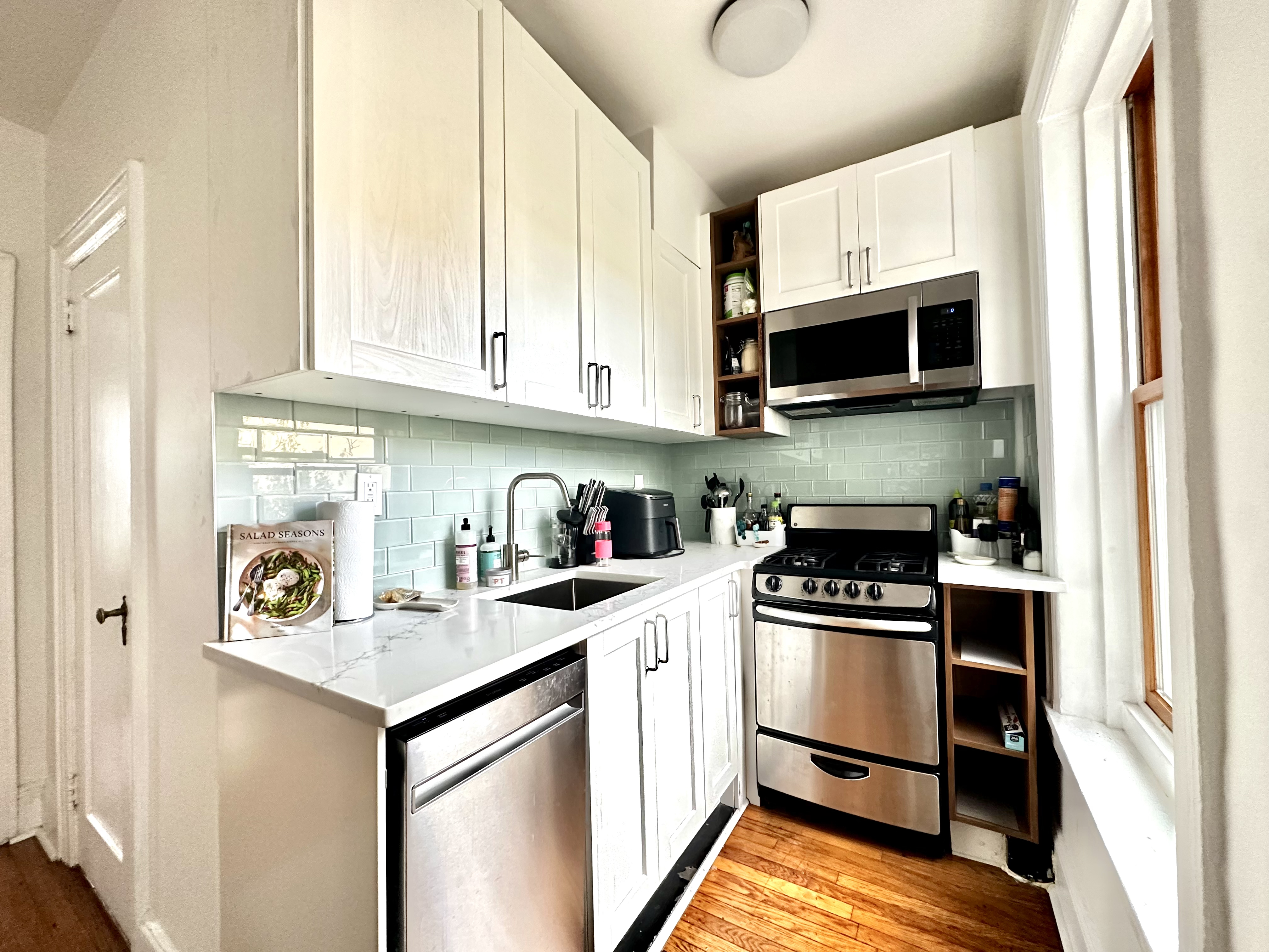 a kitchen with stainless steel appliances a stove sink microwave and cabinets